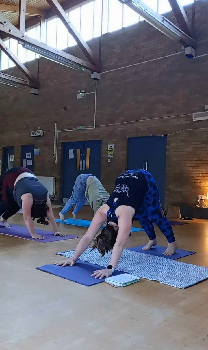 Liv demonstrating downward-facing dog during a Yoga class